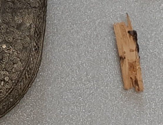 Fragment de manche en bois à côté du fourreau ciselé